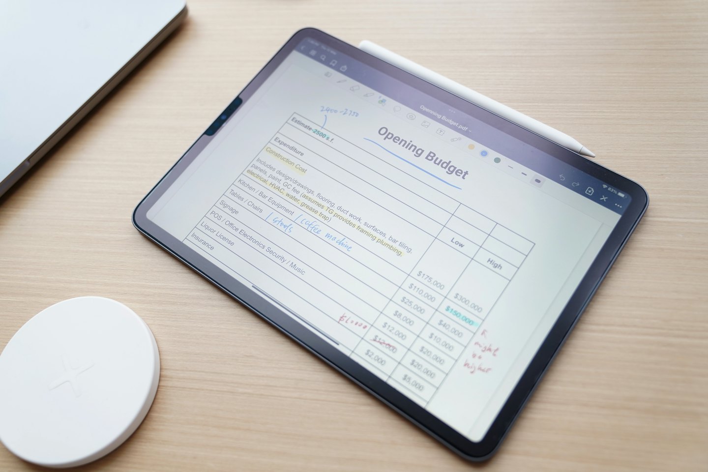 Tablet showing a digital budget spreadsheet with a stylus on screen.